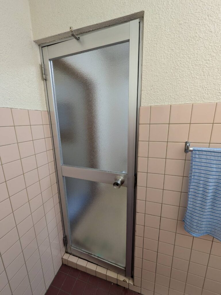 一宮市の浴室リフォーム現場。リシェント浴室開きドア施工前の古いドアの様子。