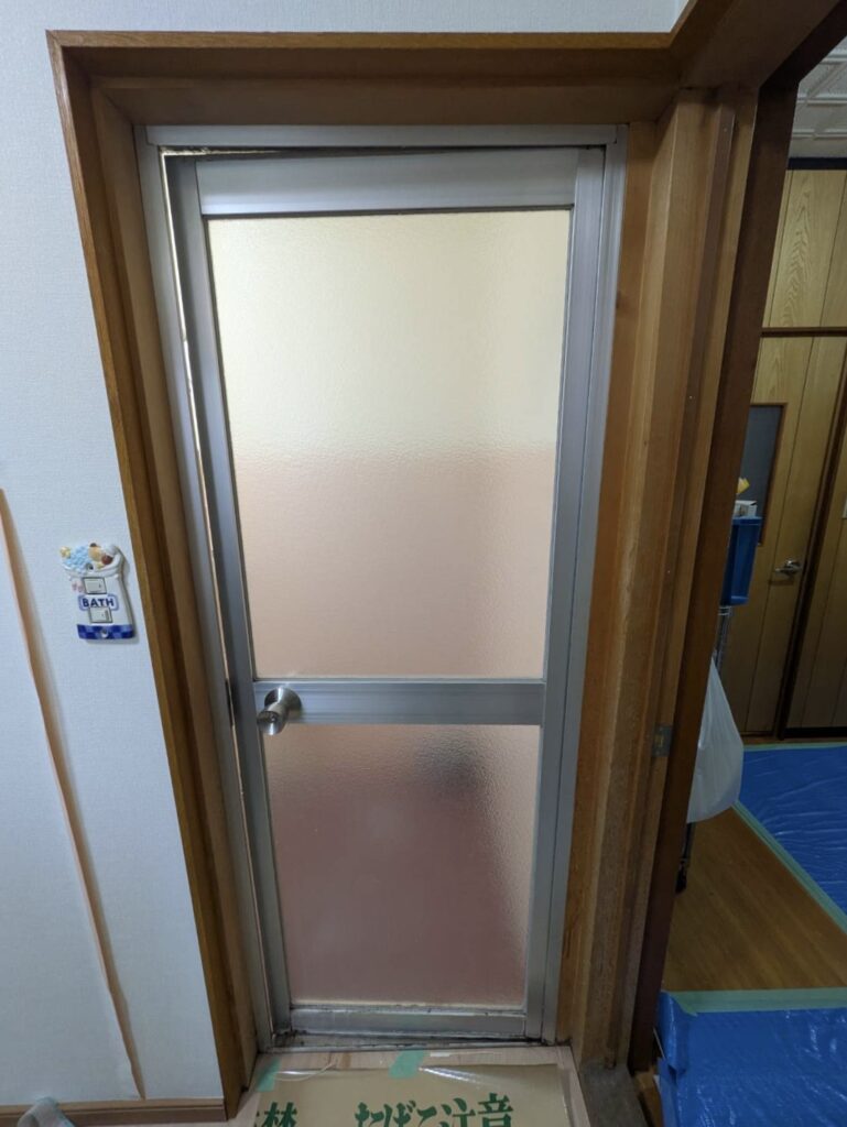 一宮市の浴室リフォーム現場。リシェント浴室開きドア施工前の古いドアの様子。